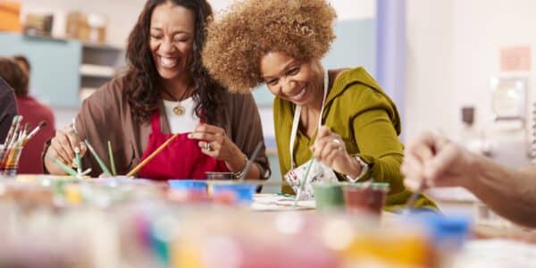 Two Mature Women Attending Art Class In Community Centre Together